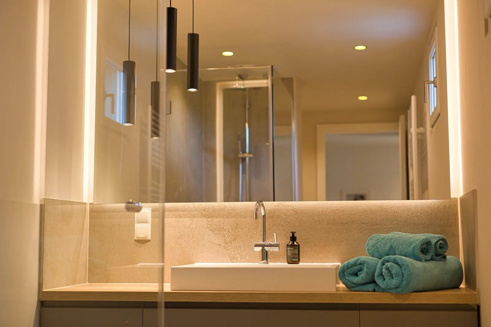 Badezimmer mit Marmoroberflächen und dezenten Lichtakzenten.