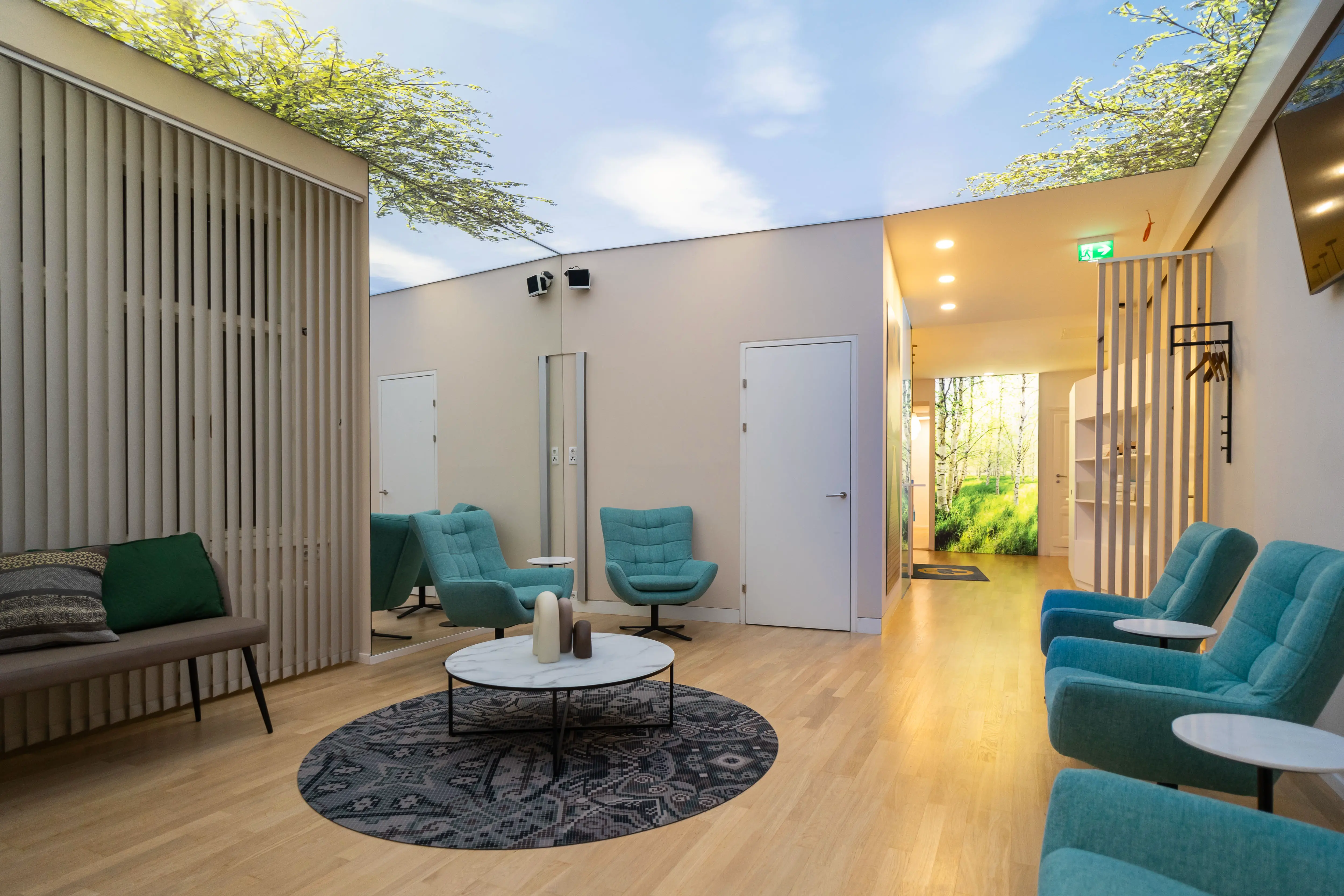 Wartebereich mit Holzlamellen als Raumteiler, modernen Sesseln und zentralem Tisch.