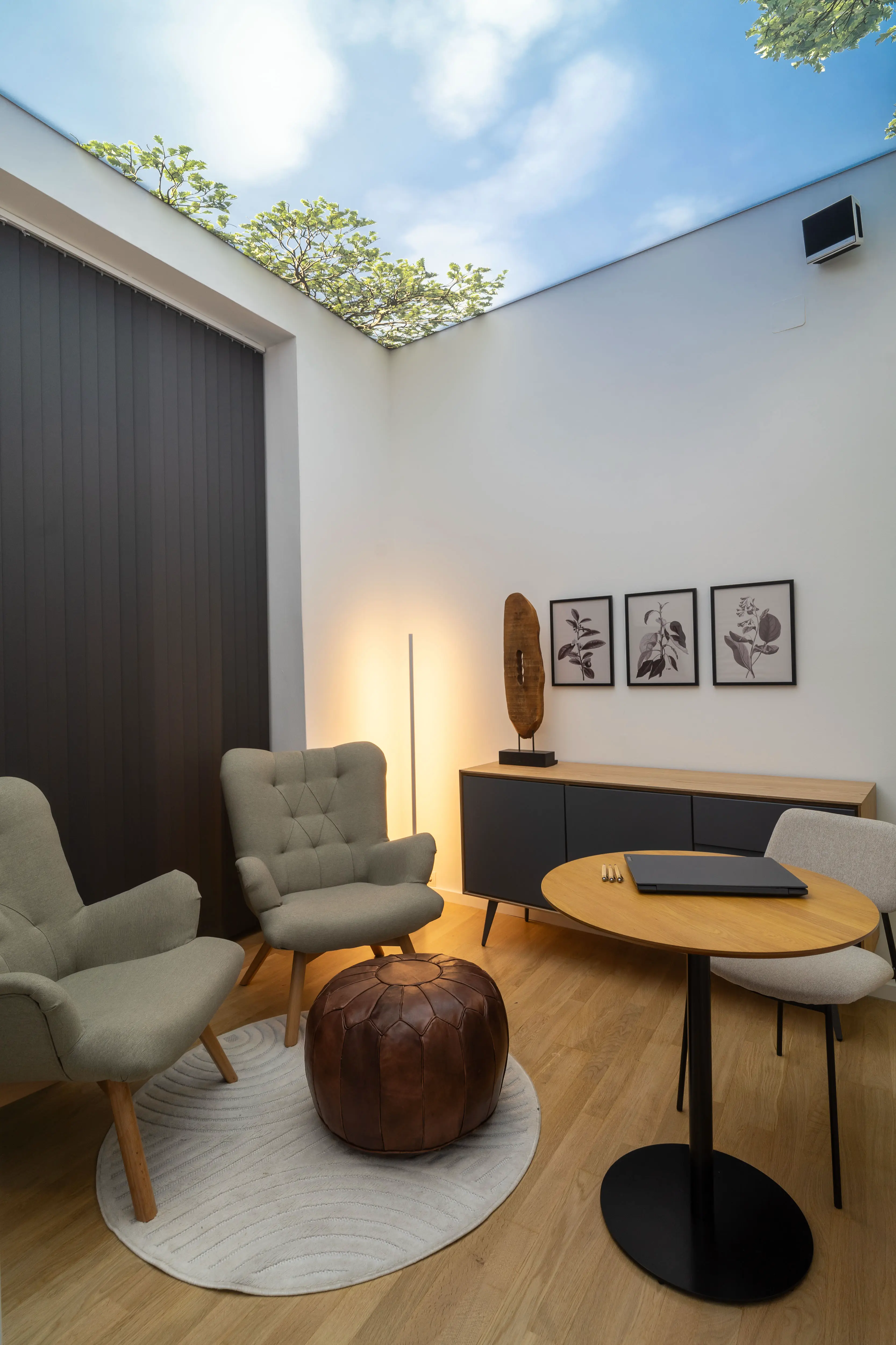 Loungebereich mit bequemen Sesseln und dezenter Wanddekoration mit Naturbildern.