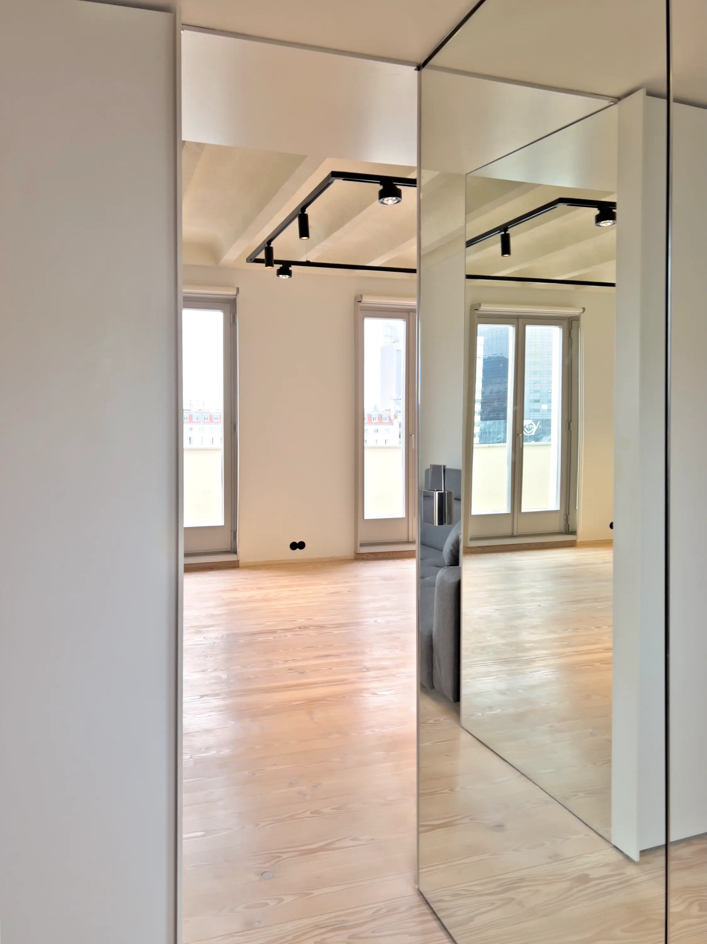 Minimalistischer Flurbereich mit bodentiefen Spiegeln und warmem Holzfußboden.