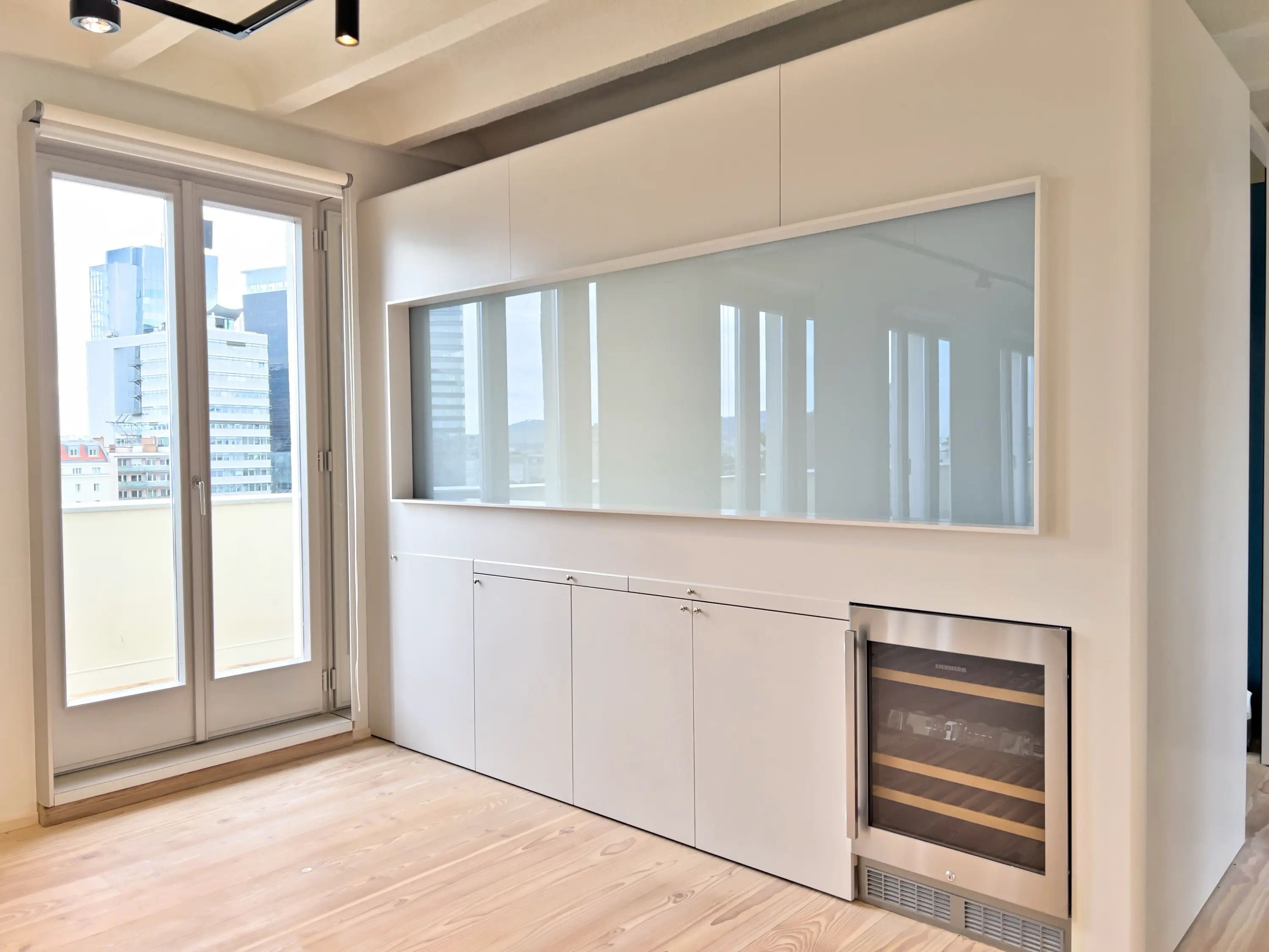 Schrankwand mit Glasfront und integriertem Weinkühlschrank im offenen Wohnbereich.