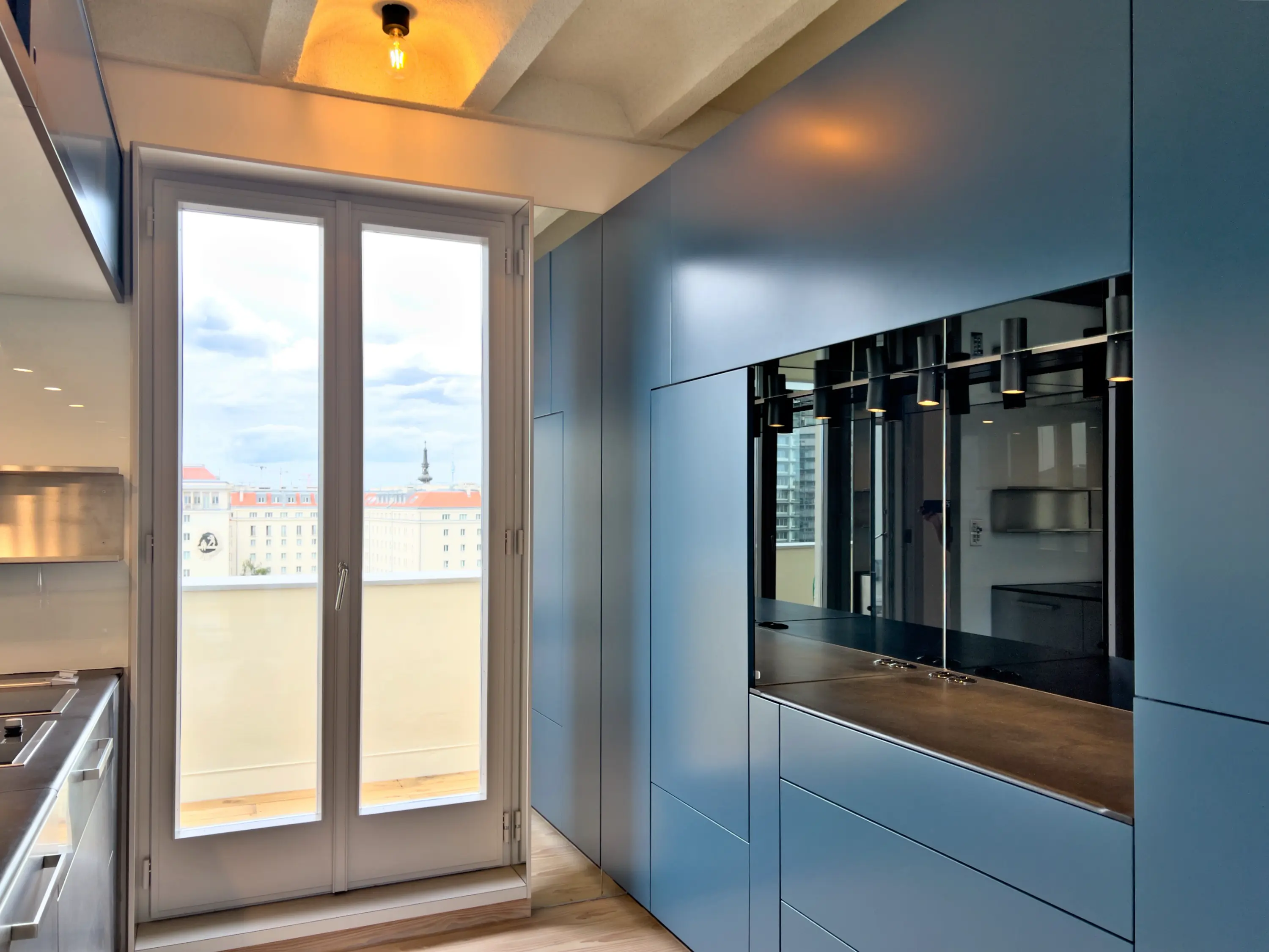 Küche mit blauen Hochglanz-Schrankfronten und reflektierender Spiegelrückwand.